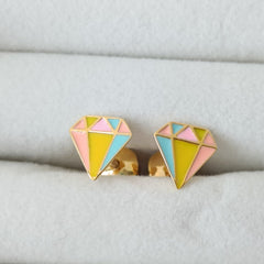 Colorful geometric earrings on a white jewelry display.