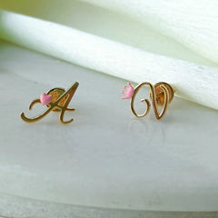 Gold earrings with pink stones on a white fabric background